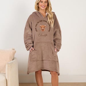 May include: A brown fleece blanket hoodie with a cow graphic and the text "Love you til the cows come home Charlotte".