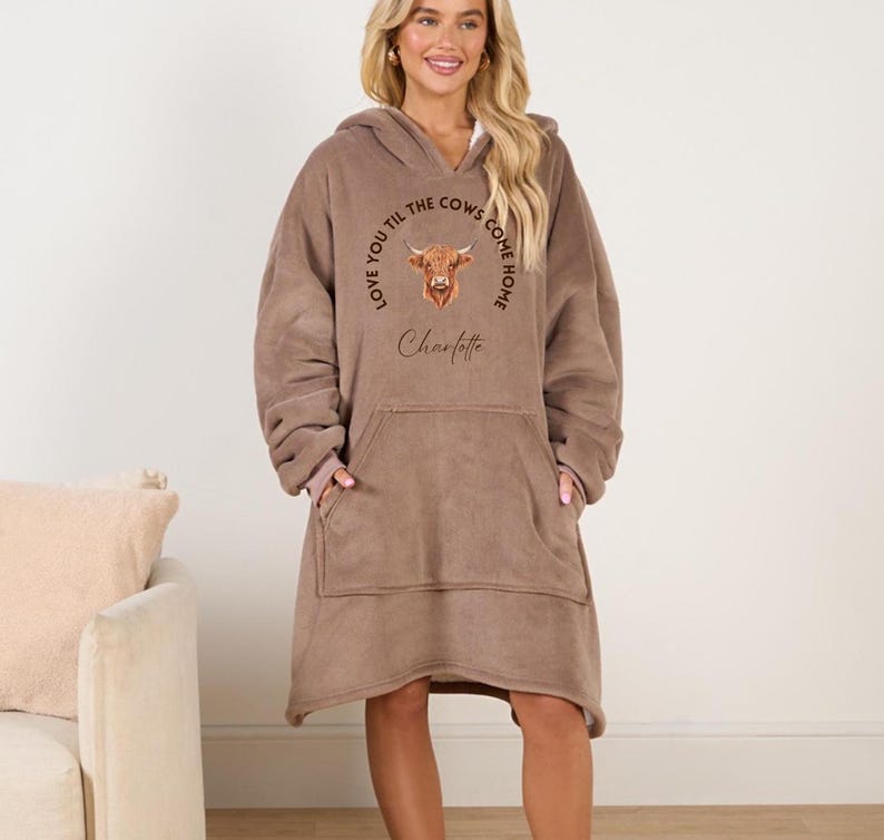 May include: A brown fleece blanket hoodie with a cow graphic and the text "Love you til the cows come home Charlotte".