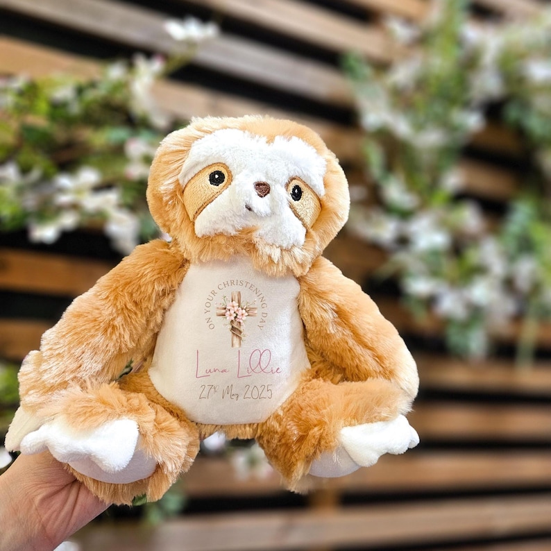 Op de afbeelding: Een pluche luiaard in bruin- en cr&egrave;metinten, met een witte buik. De luiaard heeft geborduurde ogen en een kleine neus. De buik heeft een gepersonaliseerd ontwerp met de tekst "On Your Christening Day" en een naam en datum.