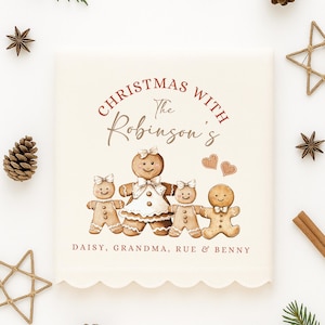 May include: A cream-coloured Christmas-themed decorative item with a gingerbread family illustration. The text "Christmas with The Robinson's" is displayed above the gingerbread figures, with names below. The item has a scalloped edge.