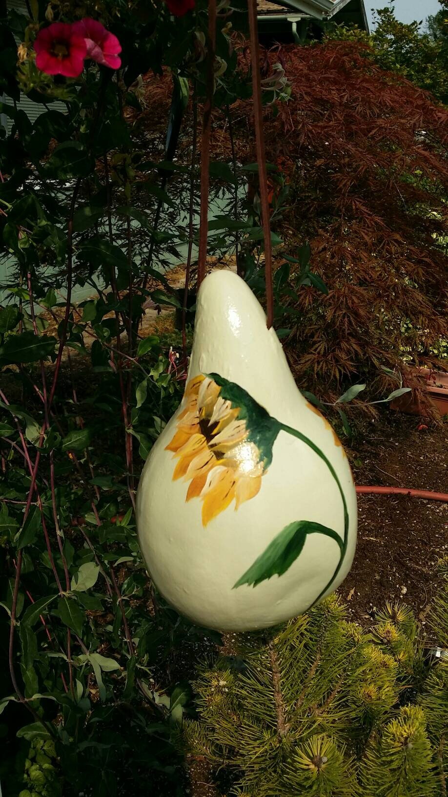 Hand painted gourd birdhouse with sunflower and butterfly on a light