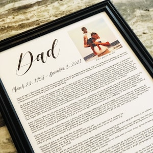 May include: A framed black and white photo of a father and son on a beach. The photo is accompanied by a handwritten message about the father, who passed away on December 3, 2021. The message includes a list of things the father enjoyed, such as family gatherings, fishing, and spending time with his loved ones.
