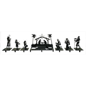 May include: A black metal nativity scene silhouette featuring a central stable with a star, palm trees, and figures including kneeling individuals, animals, and standing figures holding staffs, all arranged on individual flat rectangular bases.