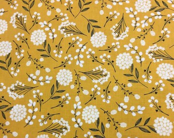 May include: A yellow fabric with a white floral pattern. The pattern features small white flowers and larger white flower clusters with green stems.