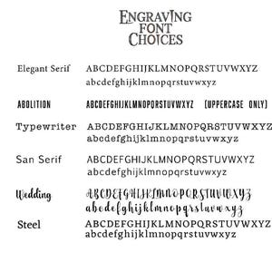 Op de afbeelding: Een weergave van graveerlettertypekeuzes, waaronder Elegant Serif, Abolition, Typewriter, San Serif, Wedding en Steel. Elk lettertype wordt weergegeven met het alfabet in hoofdletters en kleine letters, behalve Abolition, dat alleen hoofdletters heeft.