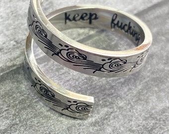 Calligraphic resin ring with handlettering and mini pencil Keep going