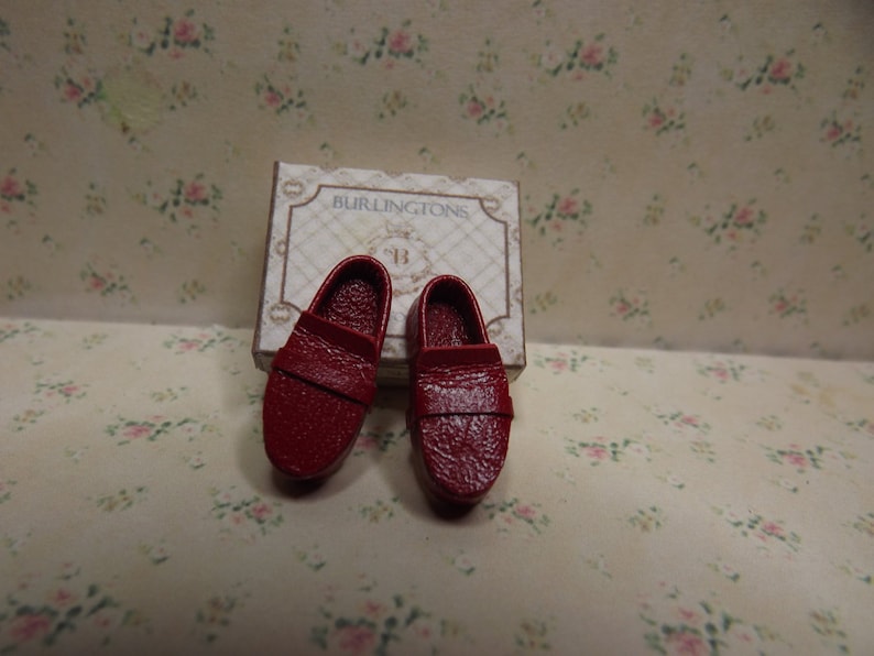 May include: A pair of red leather loafers in a box labelled "Burlingtons #13".