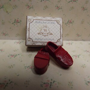 May include: Two miniature red leather shoes in a box that says "Burlintons Bespoke Footwear".