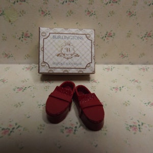 May include: A pair of red leather shoes with a box that says "BURLINGTONS BESPOKE FOOTWEAR".