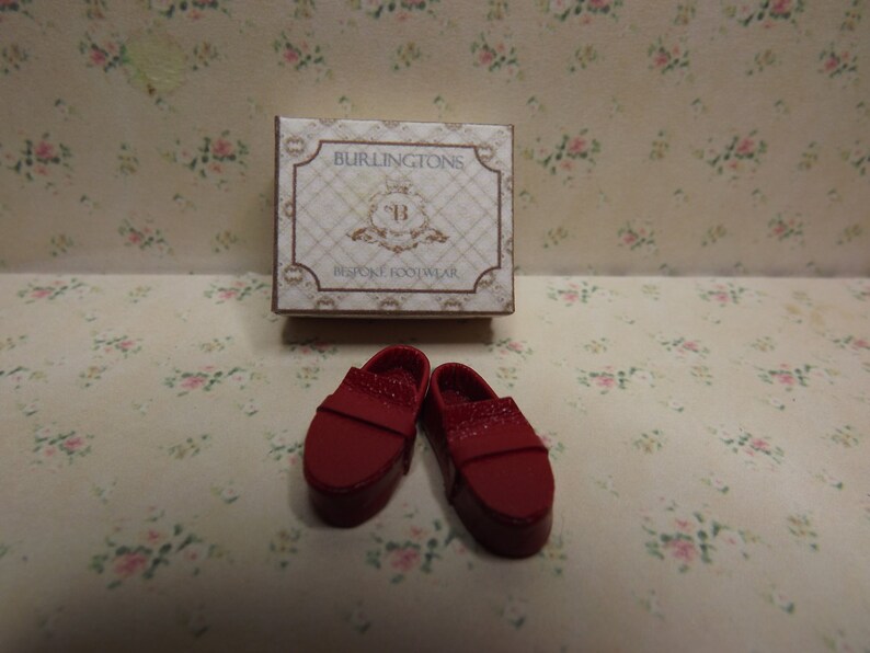 May include: A pair of red leather shoes with a box that says "BURLINGTONS BESPOKE FOOTWEAR".