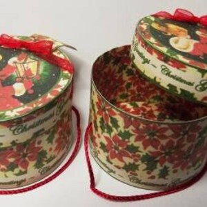 May include: Two round, red and green Christmas gift boxes with a poinsettia design. The boxes have a white ribbon and the text "Christmas Greetings".