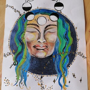 May include: A watercolour painting of a woman with blue and green hair, closed eyes, and a serene expression. A circle of moons in various phases surrounds her head, and gold glitter dots are scattered around the edges of the painting. The artist's signature, "Gem", is in the bottom right corner.