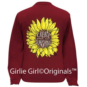 May include: Burgundy long-sleeve shirt with a sunflower graphic and the text "Create your own sunshine".
