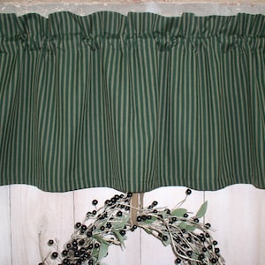 May include: Green and tan striped valance with a ruffled edge. The valance is made of a cotton fabric and is perfect for adding a touch of country charm to any kitchen or dining room.