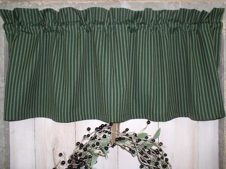 May include: Green and tan striped valance with a ruffled edge. The valance is made of a cotton fabric and is perfect for adding a touch of country charm to any kitchen or dining room.