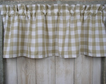 May include: A tan and white gingham valance with a ruffled top edge. The valance is hanging on a window.