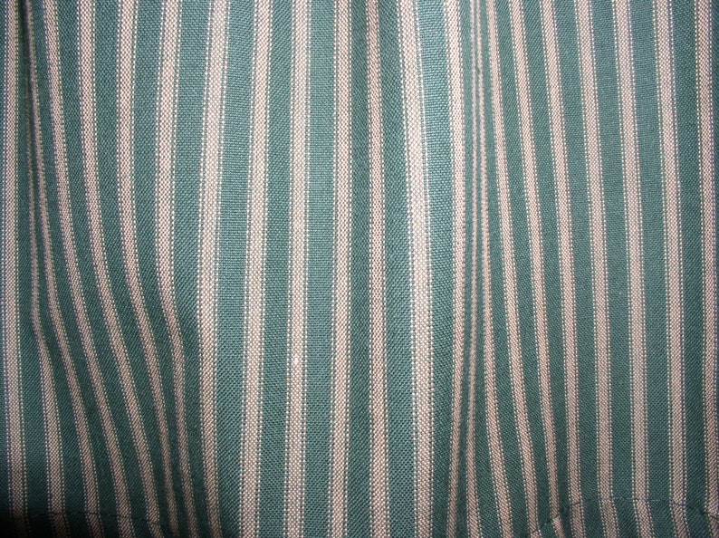 May include: Close-up of a fabric with alternating teal and white stripes. The fabric has a woven texture.