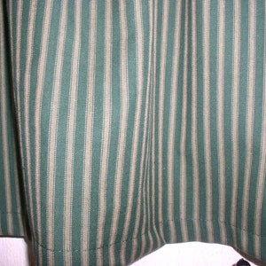May include: Green and white striped fabric with a subtle texture. The fabric has a woven appearance and is ideal for crafting projects.