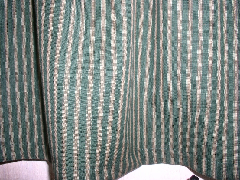 May include: Green and white striped fabric with a subtle texture. The fabric has a woven appearance and is ideal for crafting projects.