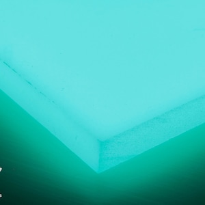 Puede incluir: Primer plano de una lámina de acrílico azul turquesa brillante con una superficie ligeramente texturizada. La lámina está iluminada desde atrás, creando un efecto brillante.