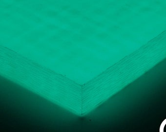 Op de afbeelding: Een close-up van een vel groen koolstofvezelmateriaal. Het materiaal heeft een geweven textuur en wordt verlicht met een heldergroen licht.