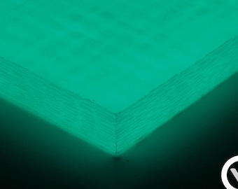 Op de afbeelding: Een close-up van een vel groen koolstofvezelmateriaal. Het materiaal heeft een geweven textuur en gloeit onder een blacklight.
