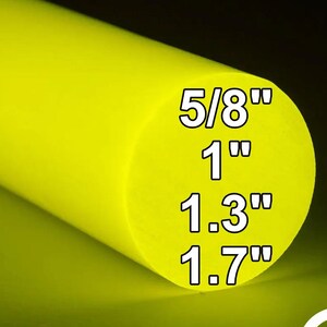 Może przedstawiać: Jaskrawożółty pręt cylindryczny o gładkim, matowym wykończeniu. Okrągła powierzchnia czołowa zawiera tekst 5/8", 1", 1.3" oraz 1.7" w białym kolorze, wskazujący dostępne opcje średnicy dla tego solidnego elementu przemysłowego.