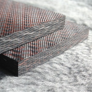 May include: Two pieces of dark brown and black patterned wood laminate. The laminate has a woven texture and a wavy pattern.