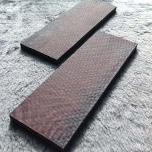 May include: Two black rectangular pieces of material with a red and black checkered pattern.