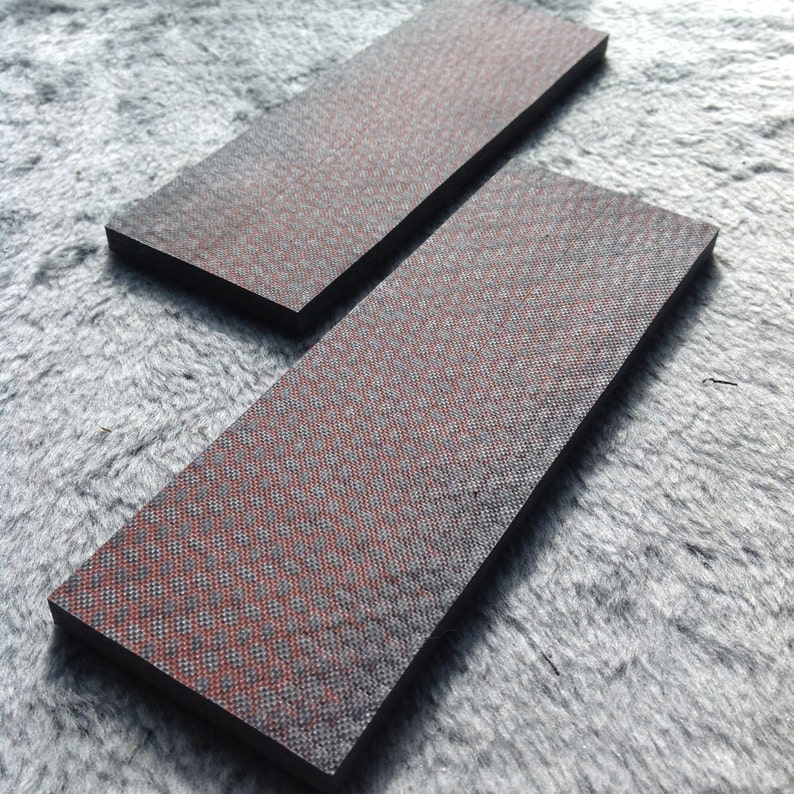 May include: Two black rectangular pieces of material with a red and black checkered pattern.