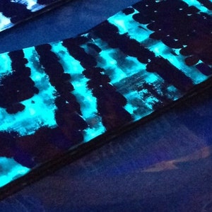 Puede incluir: Primer plano de una superficie con un patrón azul y negro. La superficie está hecha de un material que brilla en la oscuridad. La superficie es lisa y tiene un ligero brillo.