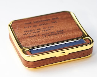 May include: A wooden rolling tray with a gold trim and a blue rolling mechanism. The tray has a quote engraved on the top: "Your happiness and tore my sails, but taught me to row with such vigor that I lost my fear of drowning."