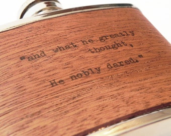 May include: A brown wooden flask with a silver top and a quote engraved on the front: "and what he greatly thought, He nobly dared."
