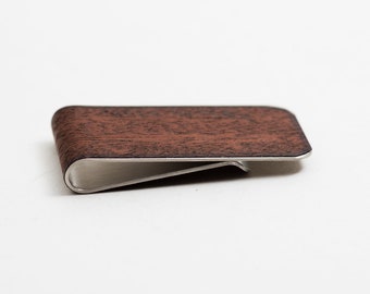 May include: A brown wood and silver money clip. The clip is made of metal and has a wood grain pattern.
