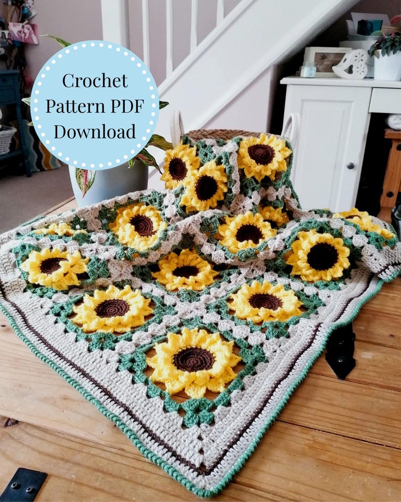 Puede incluir: Una manta de ganchillo de girasol en tonos de verde, marr&oacute;n y amarillo. La manta est&aacute; hecha de cuadrados con un dise&ntilde;o de girasol en el centro. El texto "Crochet Pattern PDF Download" es visible en la imagen.