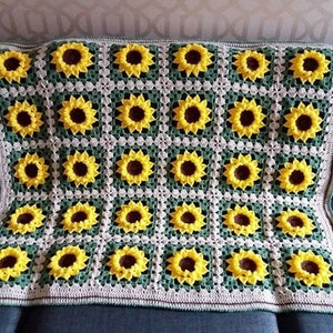 Puede incluir: Una manta de ganchillo con un patr&oacute;n de girasol en tonos de amarillo, verde y blanco.
