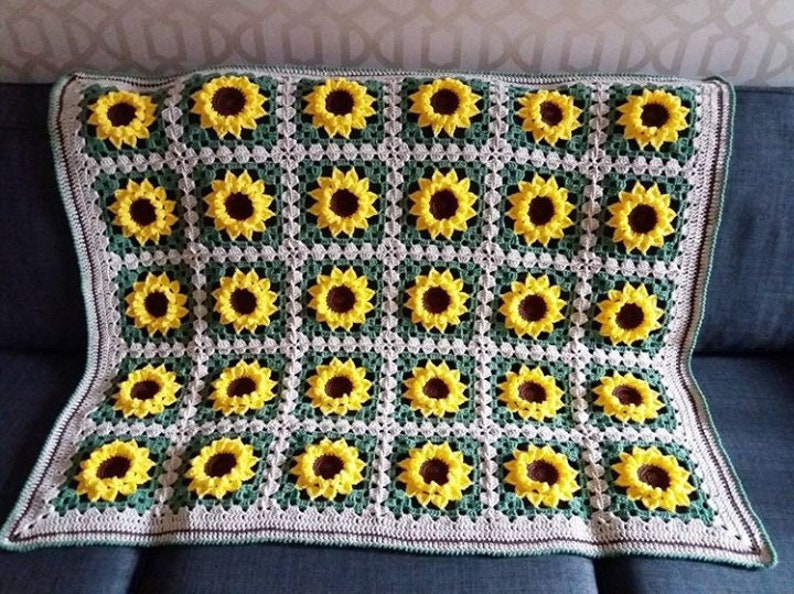 Puede incluir: Una manta de ganchillo con un patr&oacute;n de girasol en tonos de amarillo, verde y blanco.