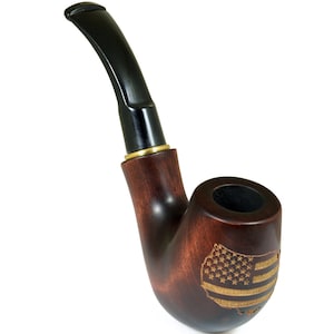 May include: A brown wooden smoking pipe with a black stem and a gold band. The bowl of the pipe is engraved with an American flag.