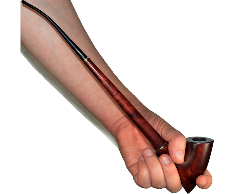 May include: A long, thin, wooden smoking pipe with a curved bowl and a black stem. The pipe is held in a hand.