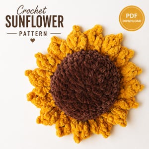 May include: A crocheted sunflower pattern with a brown center and yellow petals. The text "Crochet SUNFLOWER PATTERN" is at the top, and a "PDF DOWNLOAD" badge is in the upper right corner. The sunflower is on a white background.