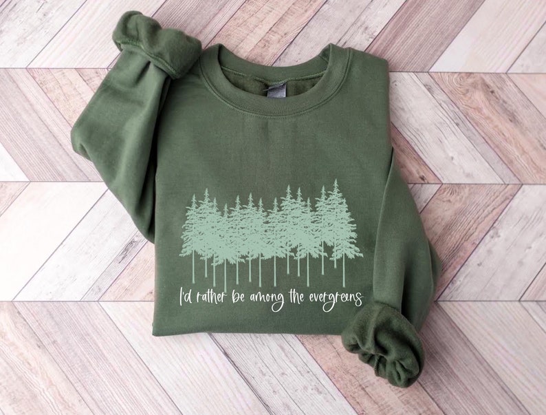 May include: A green sweatshirt with a forest scene and the text "I'd rather be among the evergreens".