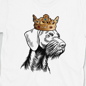 Peut inclure: T-shirt blanc avec une illustration en noir et blanc d'un chien portant une couronne dorée avec des joyaux rouges et bleus.