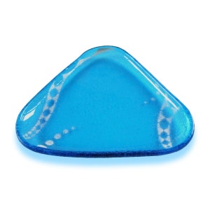 Puede incluir: Un plato de vidrio azul triangular con un patrón blanco. El plato está hecho de vidrio transparente con un tinte azul y tiene un patrón blanco en la superficie.