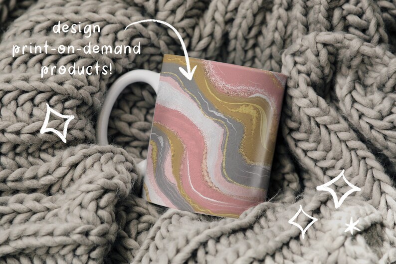 May include: A white ceramic mug with a pink, gold, and gray abstract design. The mug is sitting on a gray knitted blanket.