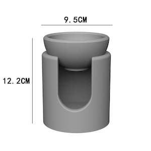 Może przedstawiać: Szary ceramiczny palnik do olejk&oacute;w eterycznych z misą na g&oacute;rze, o średnicy 9,5 cm i wysokości 12,2 cm.