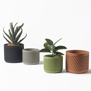 May include: Four different coloured ceramic planters with a geometric pattern. The planters are in black, grey, green, and brown. Each planter has a plant inside.