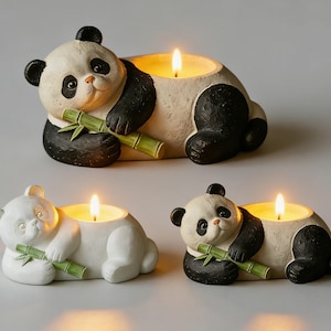 May include: Three panda-shaped candle holders. The pandas are white with black accents and are holding green bamboo. Each panda has a candle lit inside. The candle holders are decorative and add a whimsical touch to any space.