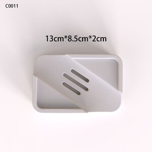 May include: White plastic soap dish with three drainage holes. The dish measures 13 inches by 8.5 inches by 2 inches.