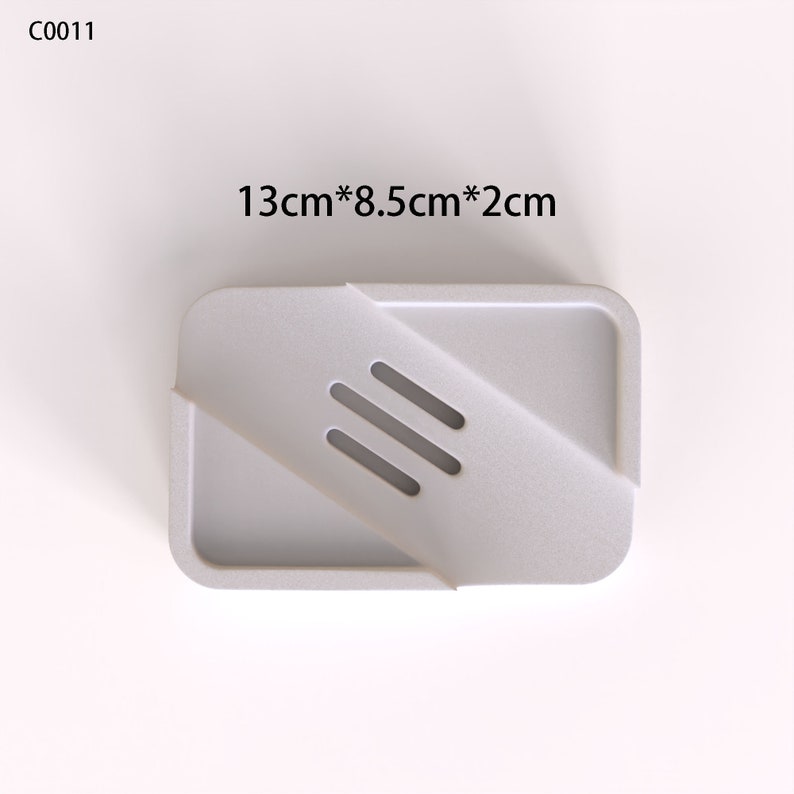 May include: White plastic soap dish with three drainage holes. The dish measures 13 inches by 8.5 inches by 2 inches.