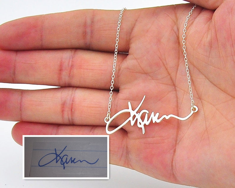 Pode incluir: Um colar prateado com um pendente com nome em estilo manuscrito. O nome em it&aacute;lico &eacute; exibido em uma m&atilde;o. Uma imagem menor mostra a assinatura no papel.